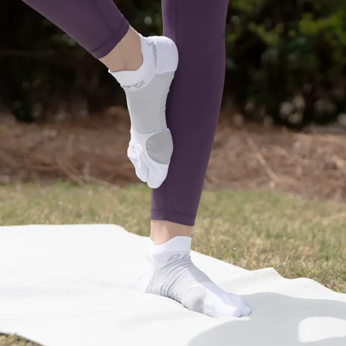 Person doing yoga outside wearing white bunion relief socks | OS1st